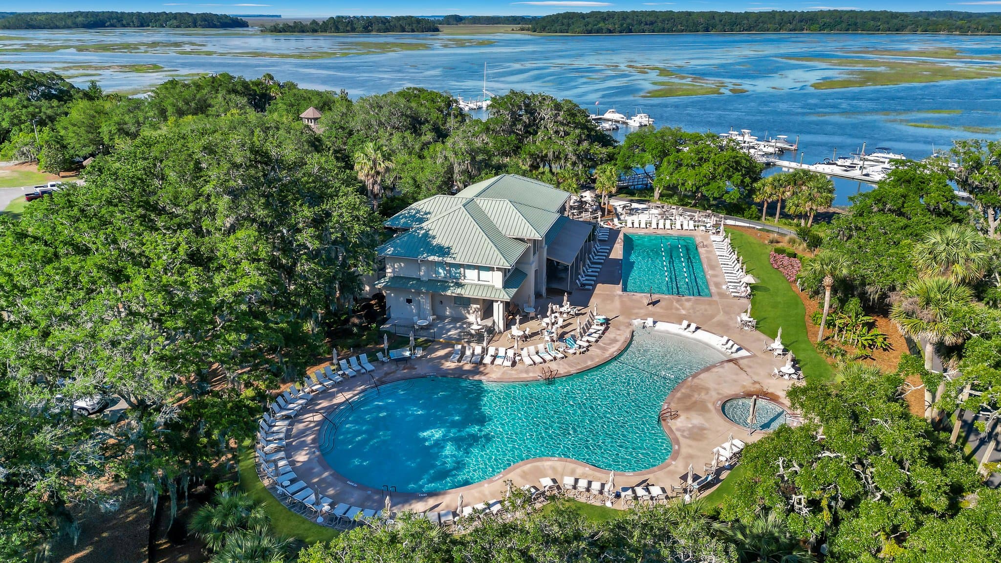 Aerial view of the Moss Creek swimming pools and clubhouse surrounded by live oaks