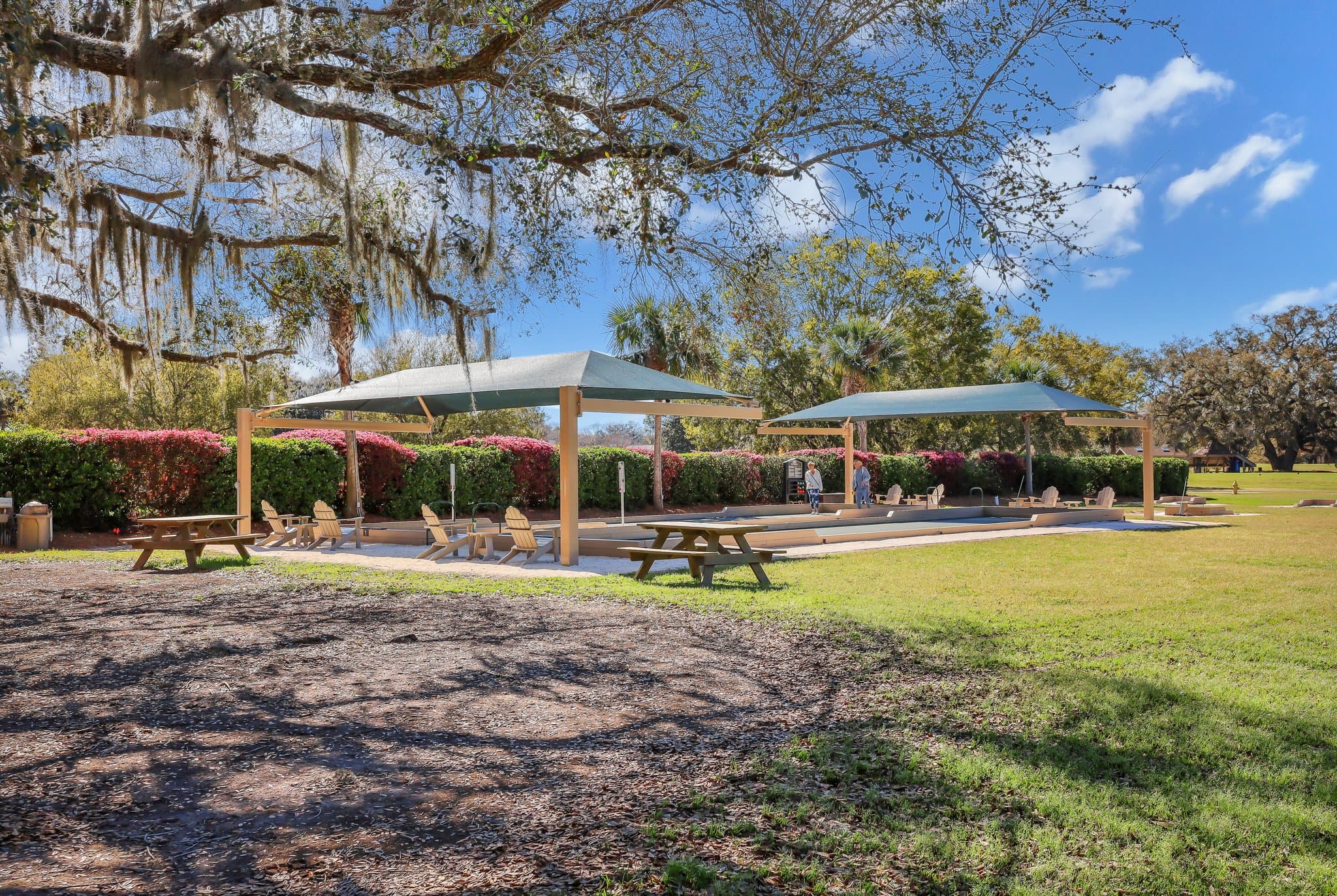 Shaded bocce courts and picnic tables under live oaks at Moss Creek, Bluffton