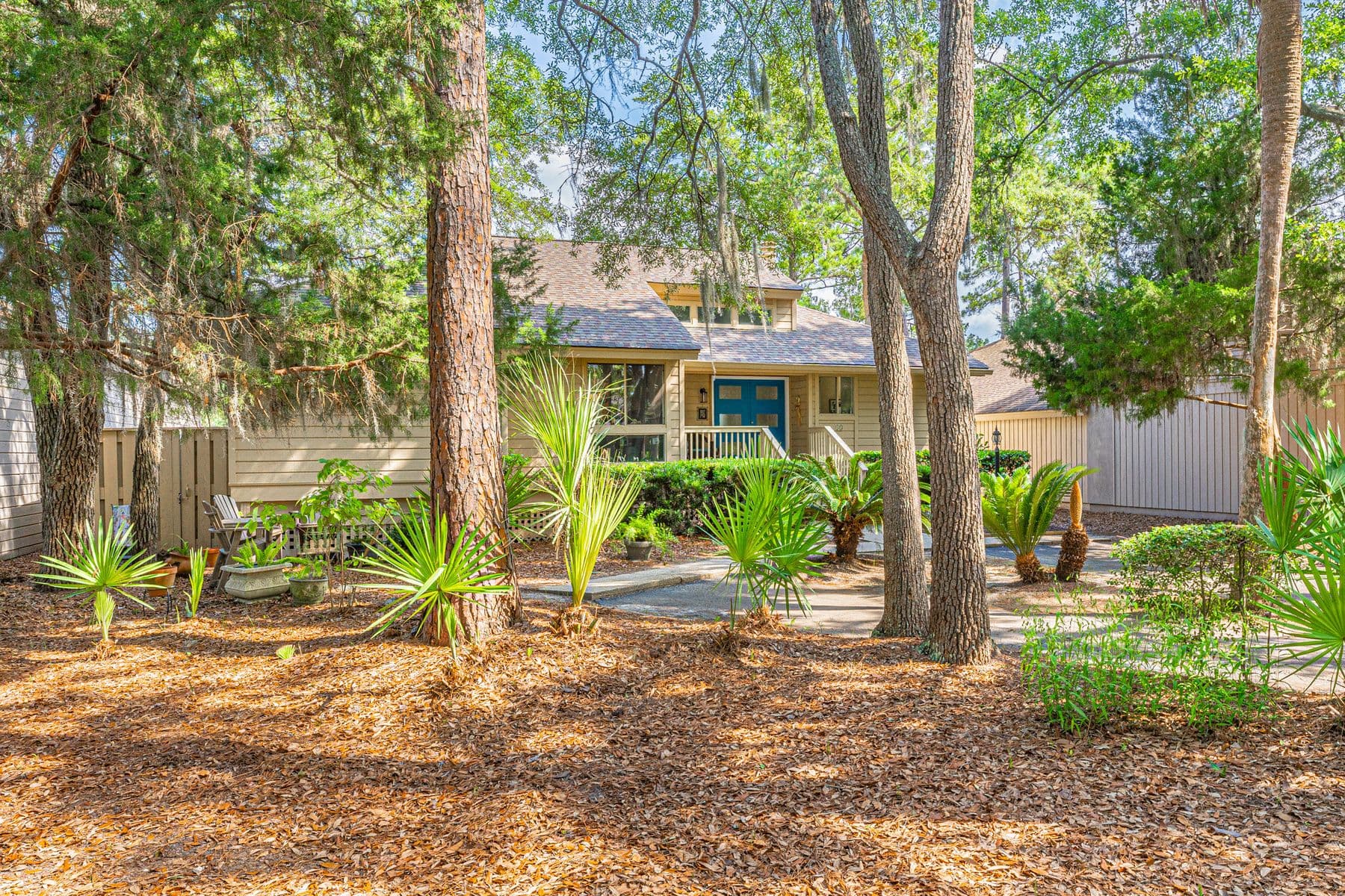 The exterior of 13 Marsh Winds among pines and palmettos