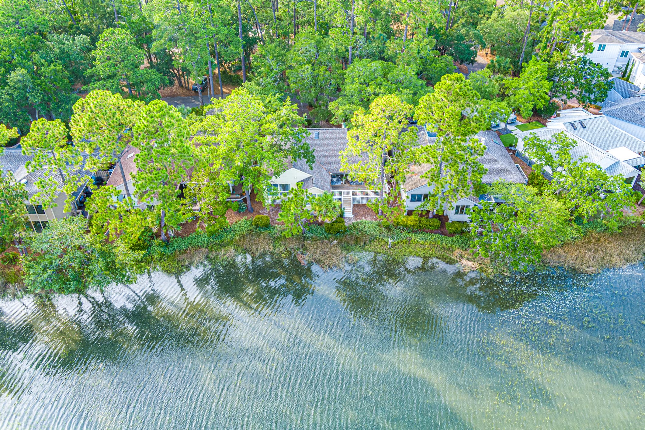 Aerial view of 13 Marsh Winds and neighbouring homes along the tidal creek in Moss Creek