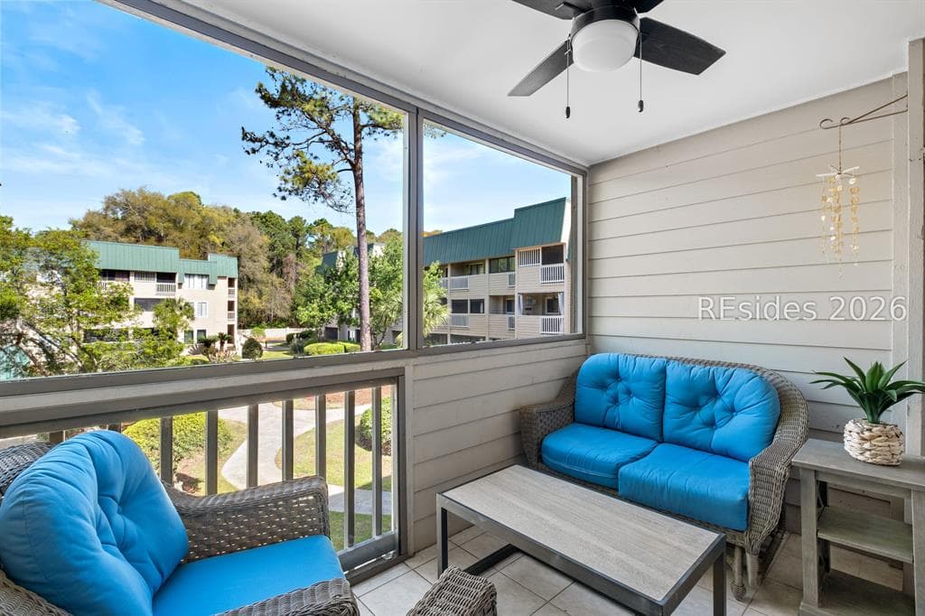 The screened porch at 239 Beach City Road with wicker seating and a view through the pines