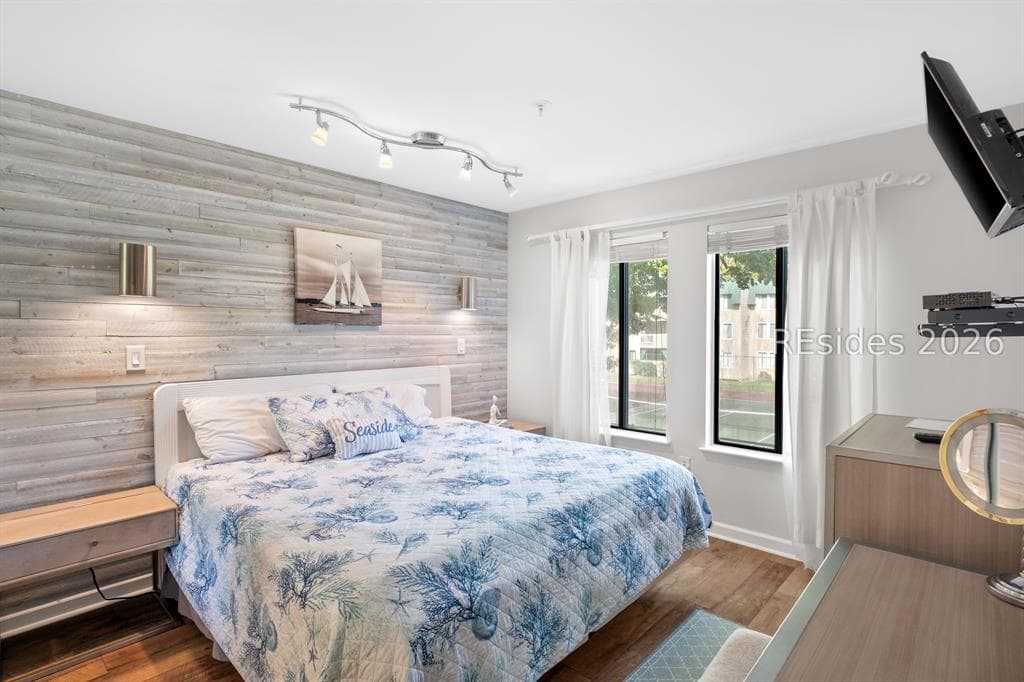 A bedroom at 239 Beach City Road with a reclaimed-wood accent wall and windows onto the trees