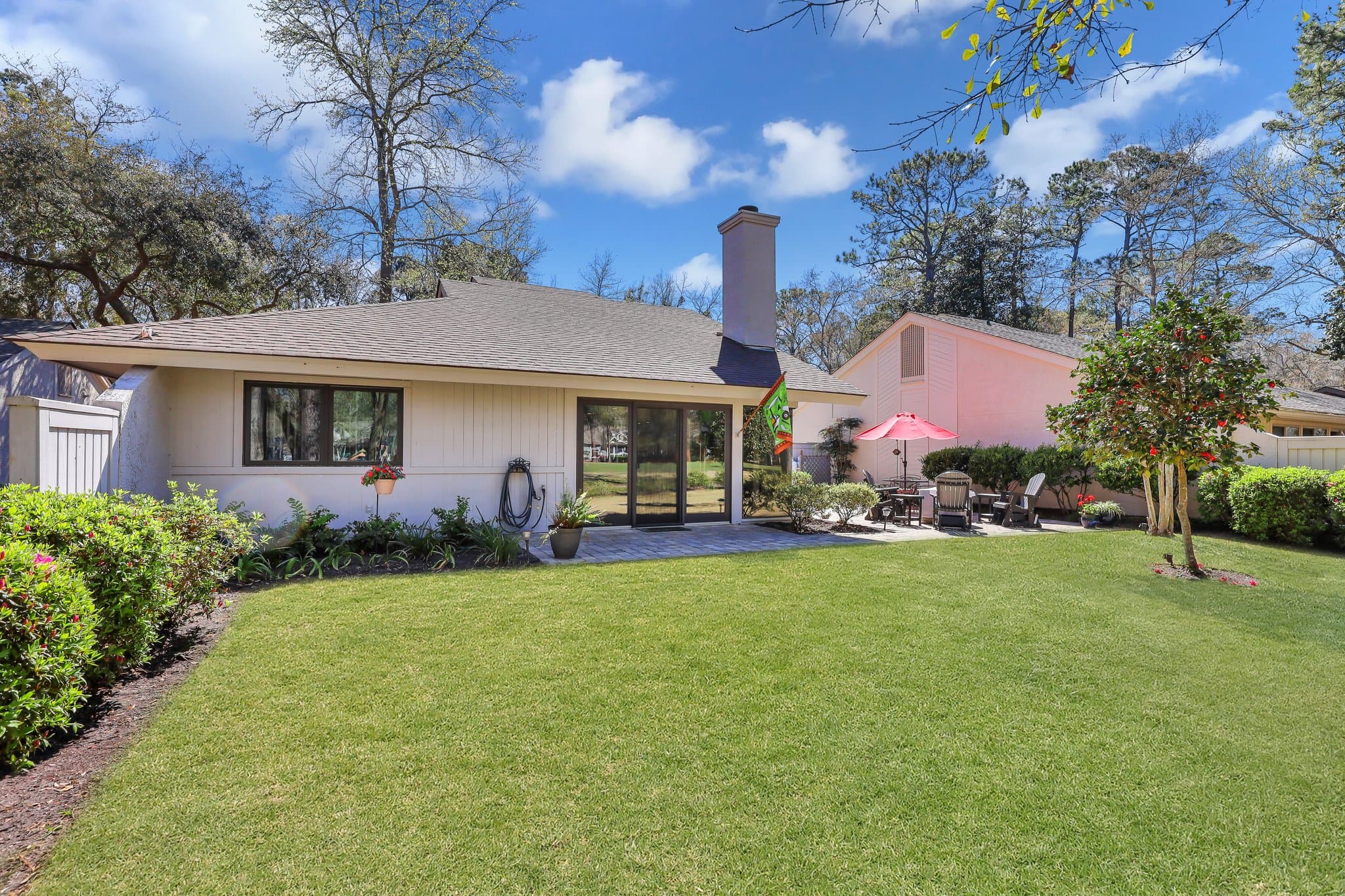 The rear patio and lawn at 59 Stable Gate, Moss Creek, looking toward the golf course
