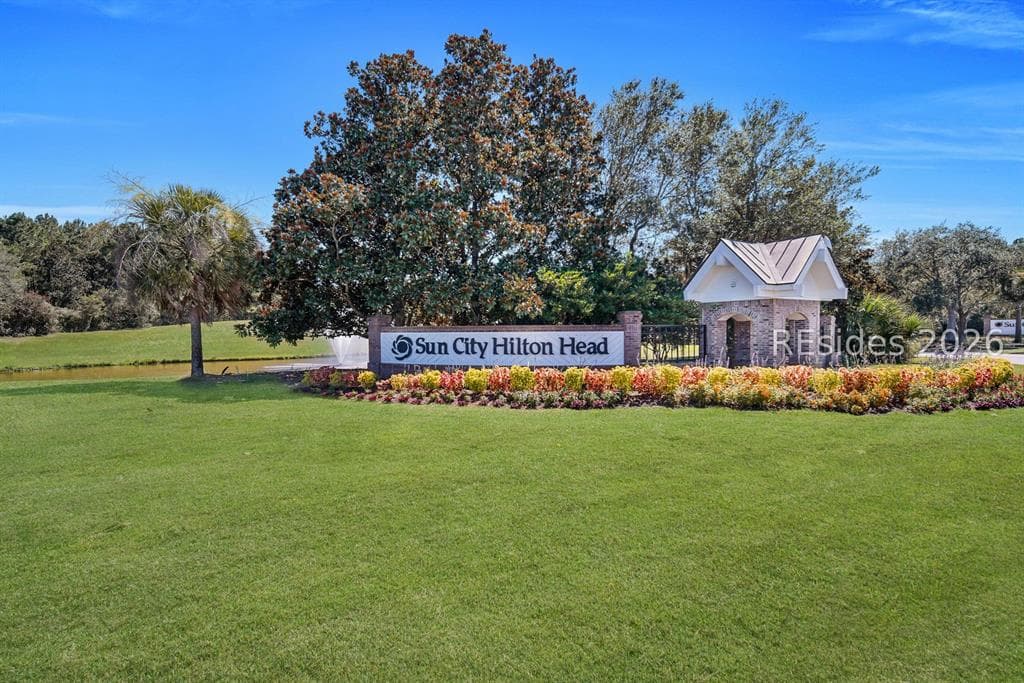 The landscaped entrance to Sun City Hilton Head in Bluffton, with the gatehouse and sign